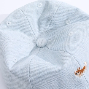 Détail de casquette bébé en jean bleu clair avec coutures et broderie Corgi de qualité