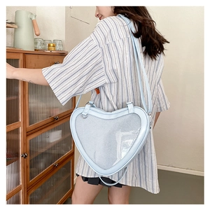 Close-up of light blue heart-shaped JK uniform bag with clear window on a model