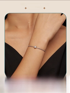 Close-up of a luxury moissanite bracelet with a six-prong round cut stone on a silver chain