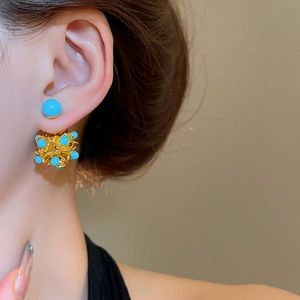 Macro view of blue resin beads in a golden hollow floral sphere design for women