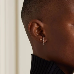 Close-up of S925 silver pearl stud and gold ear cuff with sparkling diamonds on ear