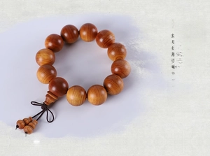 Macro shot of natural Thuja wood beads showing authentic rich oil textures and grain