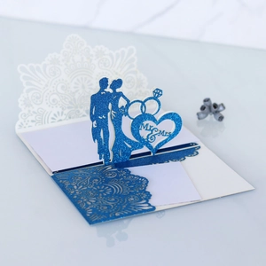 Detail of blue glitter laser cut 3D wedding card featuring Mr and Mrs with heart rings