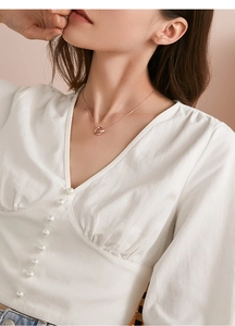 Detail showing elegant rose gold interlocking double ring necklace worn on neck