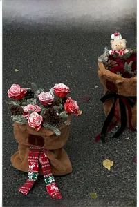 Detail of Christmas plush bear flower baskets with red scarves, pine cones and roses