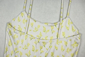 Dettaglio di canotta a fiori con spalline sottili e consistenza del tessuto liscio