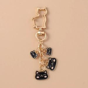 Detail of golden heart-shaped cat hook with four black feline charm pendants