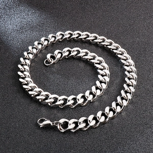 Detailed close-up of a silver Cuban link chain necklace with polished lobster clasp