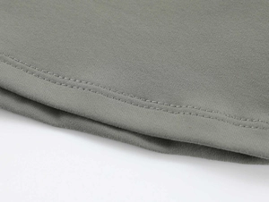 Macro shot of moss green athletic fabric showing durable double-needle stitching detail
