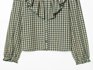 Detail of ruffled vintage neckline and green plaid pattern on cotton long sleeve shirt