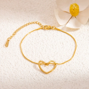 Close-up of golden stainless steel snake chain bracelet with hollow heart pendant