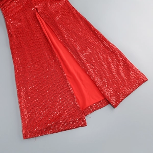 Detailed close-up of red sequined dress hemline featuring a high side slit design
