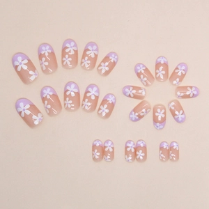 Oval lavender French press-on nails with white floral patterns on a nude base