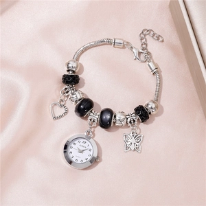 Gros plan sur la montre-bracelet à breloques argentées avec cœurs et perles noires facettées