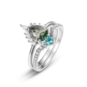 Macro shot of silver ring set with pear-shaped moss agate and blue gemstone details