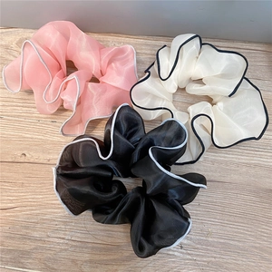 Three oversized chiffon scrunchies in pink, beige, and black with elegant piped edges