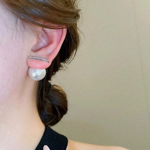 Detailed side view of silver zirconia earrings with a large white pearl back drop