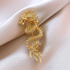 Detailed macro shot of a 14k gold plated dragon brooch with sparkling pave crystals
