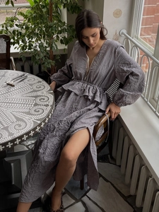 Détail de la robe plissée gris-violet montrant la taille à volants et la texture du tissu