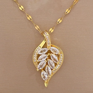 Macro detail of leaf pendant necklace featuring luxurious crystal pave in gold titanium steel