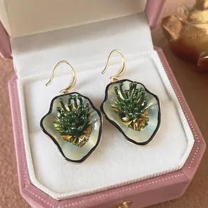 Vintage irregular flower earrings with green pearl inlay in a pink velvet jewelry box