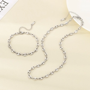 Détail d'un ensemble collier et bracelet en acier inoxydable argenté à maillons grains de café