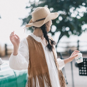 Bohemian suede fringe vest paired with a straw cowboy hat for summer vacation look