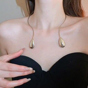 Polished silver teardrop torque necklace showing elegant metal texture on collarbone