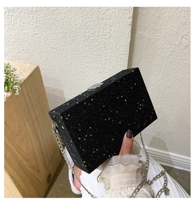 Close-up of black starlight clutch bag with velvet texture and silver chain strap