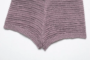 Close-up of lilac knitted fabric showing textured cotton stitching and hem detail
