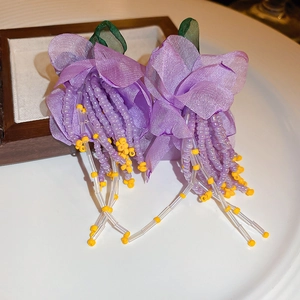 Floral tulle drop earrings featuring purple layered petals and beaded tassel accents