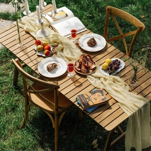 Detailed top view of a wooden folding table and chairs set on a natural sunny lawn