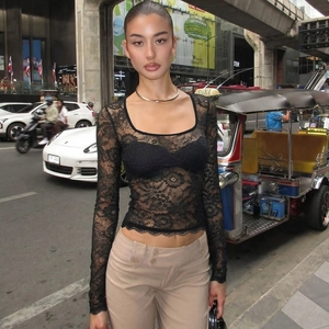 Détail d'un haut en dentelle noire transparente à manches longues et coupe ajustée chic