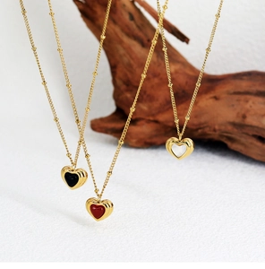 Detailed view of three heart shaped necklaces with black, red and white agate inlay gems