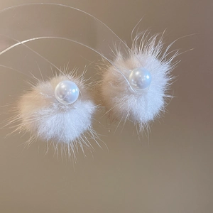 Detail showing soft beige fur pompom earrings with elegant pearls for autumn style