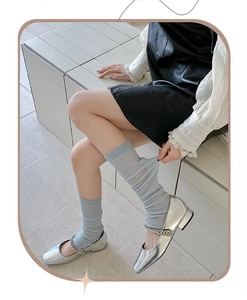 Close-up of elastic light blue knit leg warmers showing texture and ribbed structure