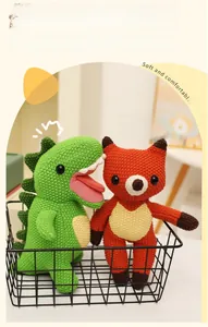 Detail of hand-knitted green dinosaur and fox plush toys in a black wire basket
