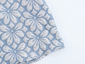 Detailansicht des Vintage-Jacquard-Stoffs in Hellblau mit 3D-Prägung weißer Blumenmuster