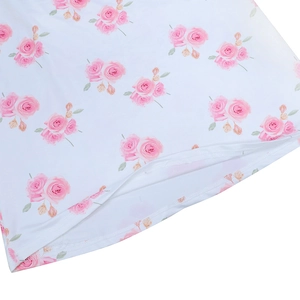 Close-up of pink rose print on white fabric with detailed hem stitching and soft texture