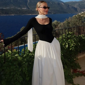 Detail of contrast patchwork maxi dress with round neck and chic white scarf accessory