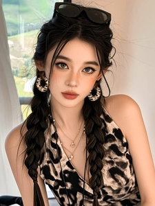 Fashion model wearing leopard print hoop earrings and layered metal necklaces in sunlight