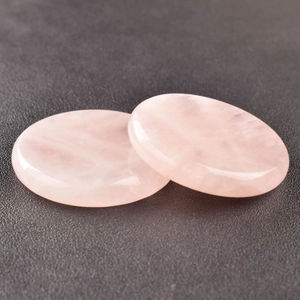 Macro shot of two polished natural rose quartz crystal discs with smooth texture
