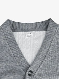 Close-up of grey knit cardigan neckline showing waffle texture and sizing label