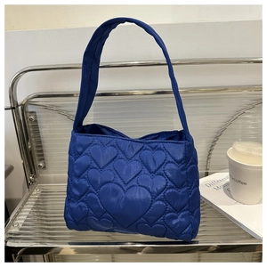 Détail du sac fourre-tout bleu matelassé avec motifs de cœur et texture nylon léger