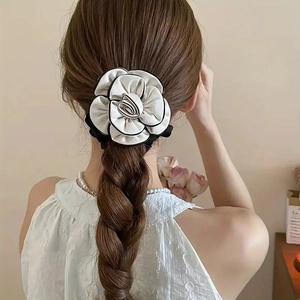 Elegant camellia flower hair scrunchie with white petals and black edges on a braid