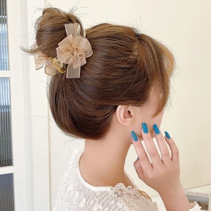 Elegant champagne lace bow hair clip securing a bun hairstyle for a refined look