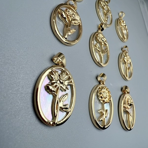 Detailed close-up of golden oval sunflower pendants with white shell inlay for DIY jewelry