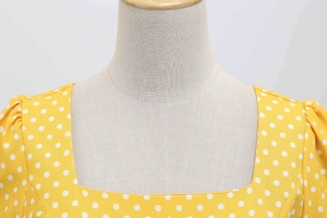 Detail showing the square neckline and white polka dots on a yellow vintage dress