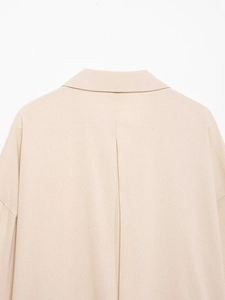 Détail du col arrière et des coutures sur une chemise en lin beige coupe ample