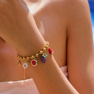 Detailed close-up of 18K gold plated bracelet with colorful enamel fruit charms